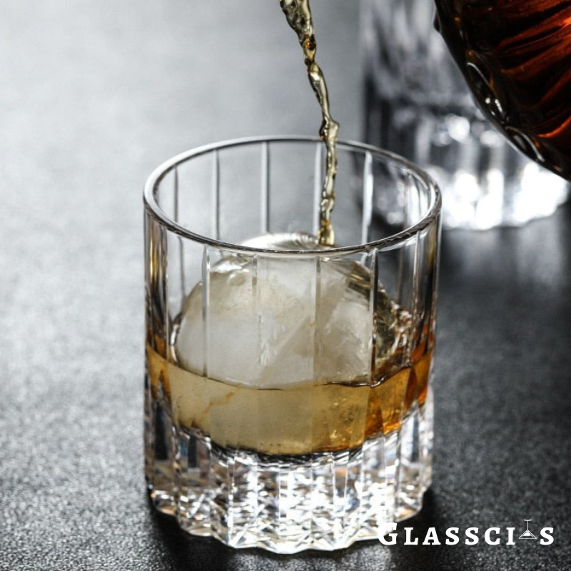 a man pouring whiskey to a hand blown whiskey glasses
