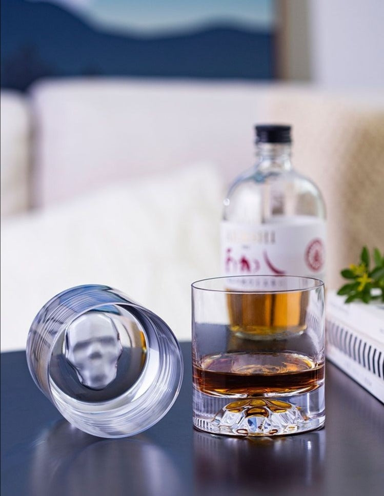 handmade whiskey glass with skull face on bottom by glasscias