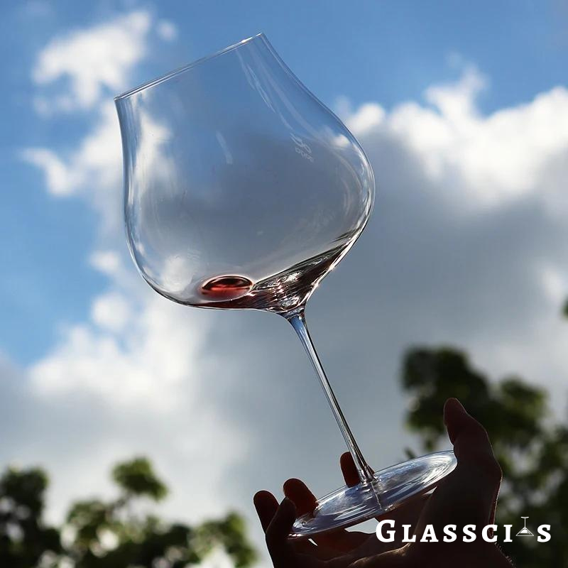 man holding roberto conterno sensory glass under the blue sky