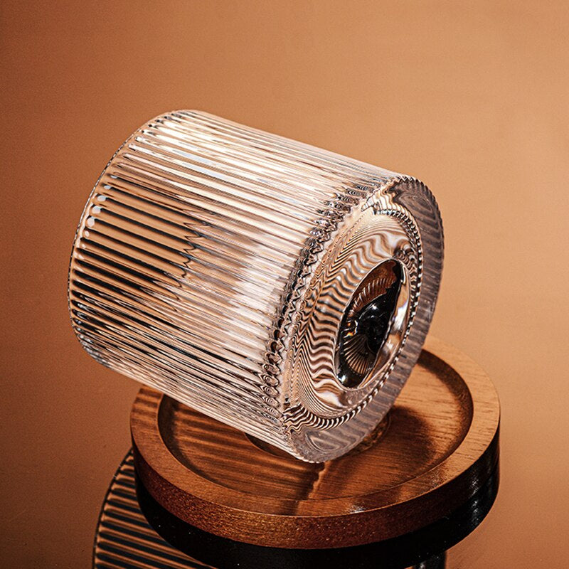 a rotating whiskey glass on a wooden coaster