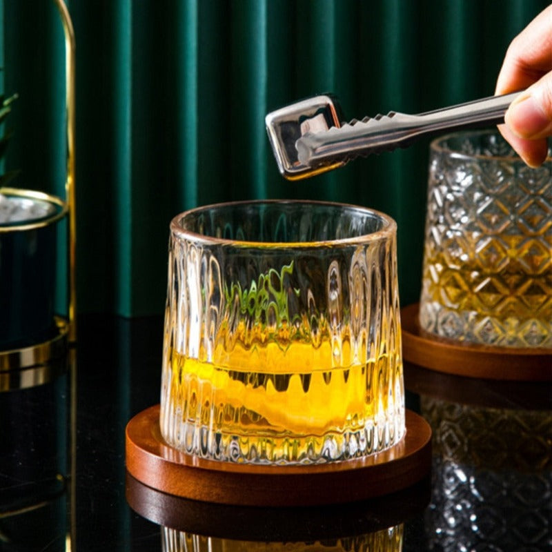 a man putting ice into a glacier whiskey glasses at fancy bar