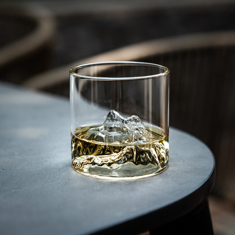 Drinkware showcasing mountain peaks emerging from amber liquid