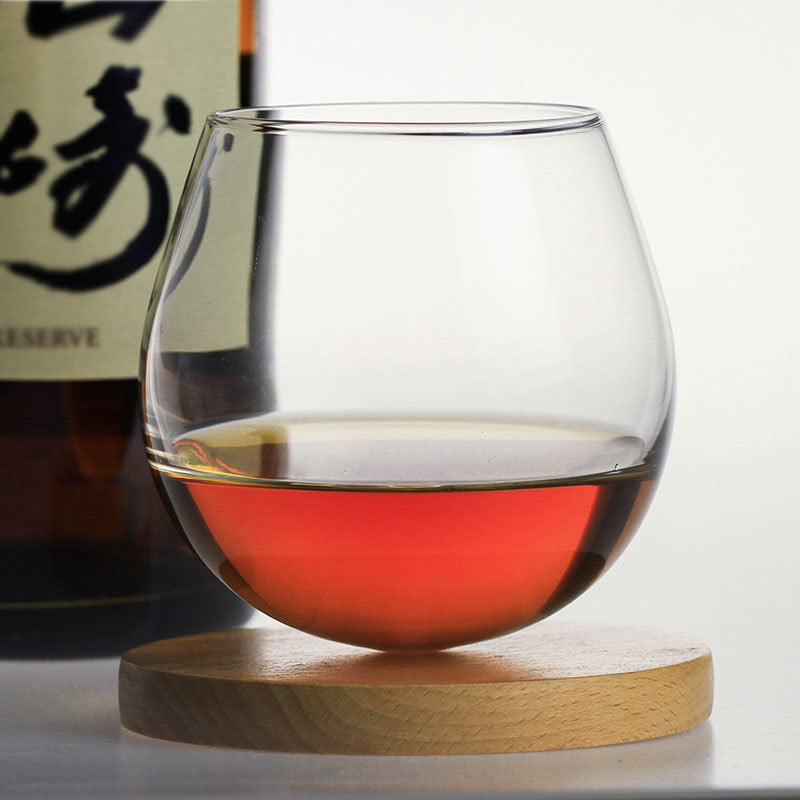 Sleek rocking whiskey glass with a narrow opening and rounded base