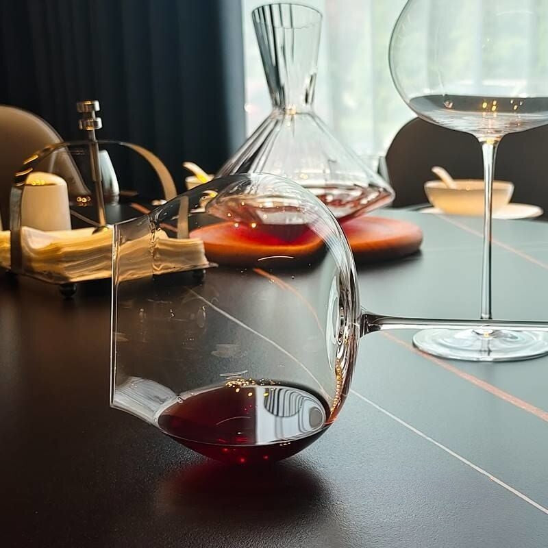 burgundy glasses laying horizontal on the table | Glasscias