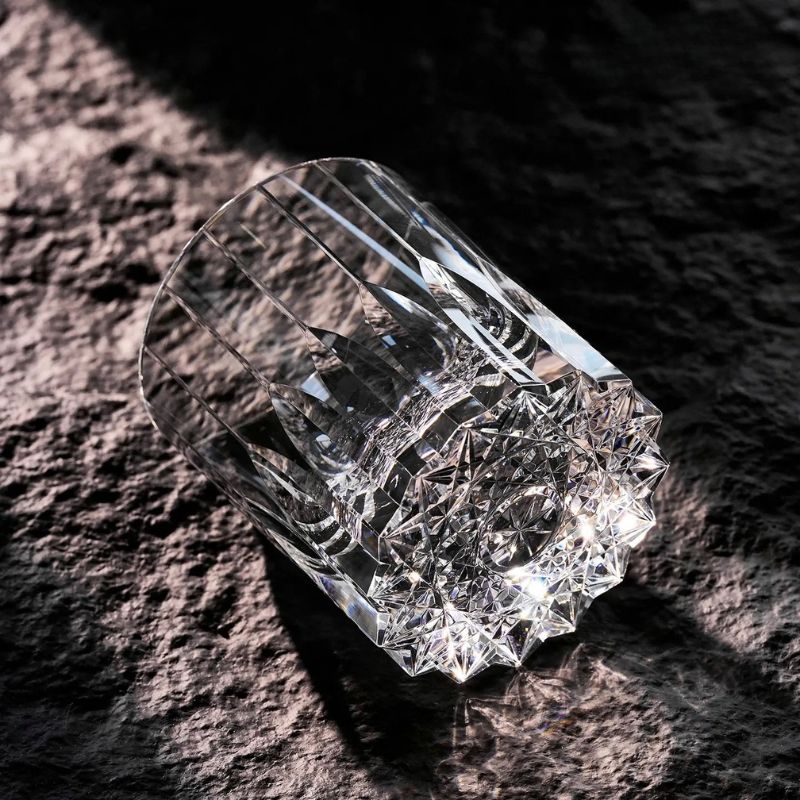 Hand-cut crystal whiskey glass lying on stone in sunlight