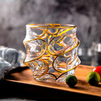 Spiraled gold rim glassware adorned with gold edging, reflecting luxury