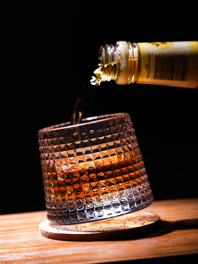 someone pouring whiskey to a rocking whiskey glasses