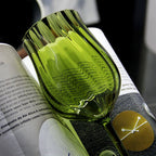 Close-up of green wine glass reflecting light