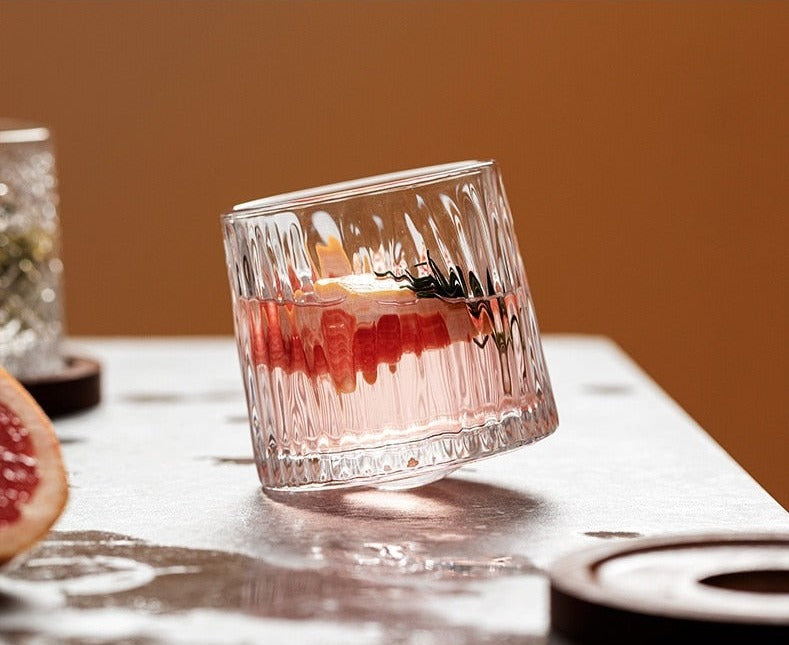 a ribbed whiskey glass filled with whiskey on a table 